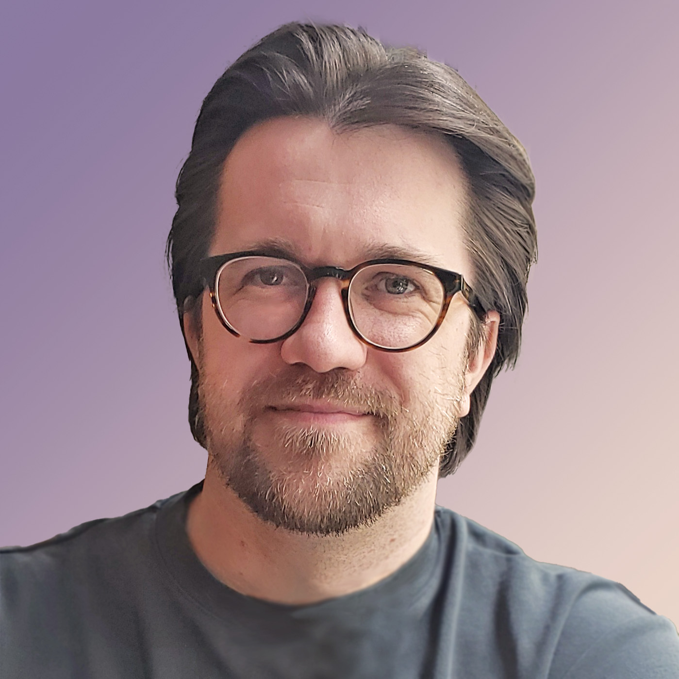 It's me! A white man smiling with medium-short brown hair, glasses, and a grey t-shirt.