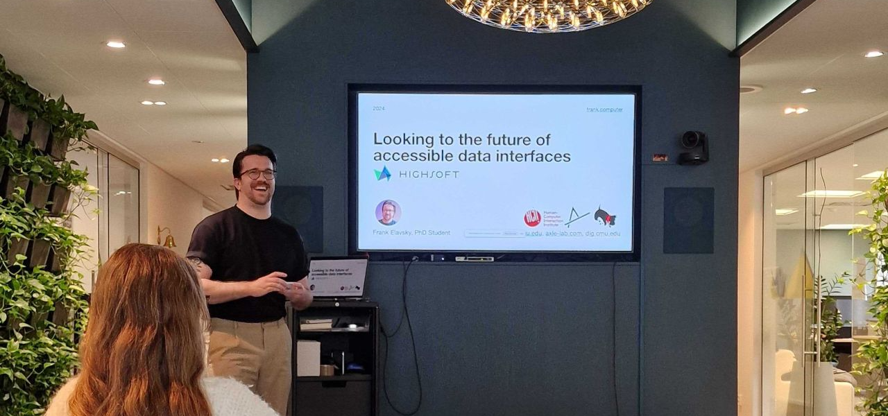 I'm standing in front of a screen, laughing. The screen says Looking to the future of accessible data interfaces.