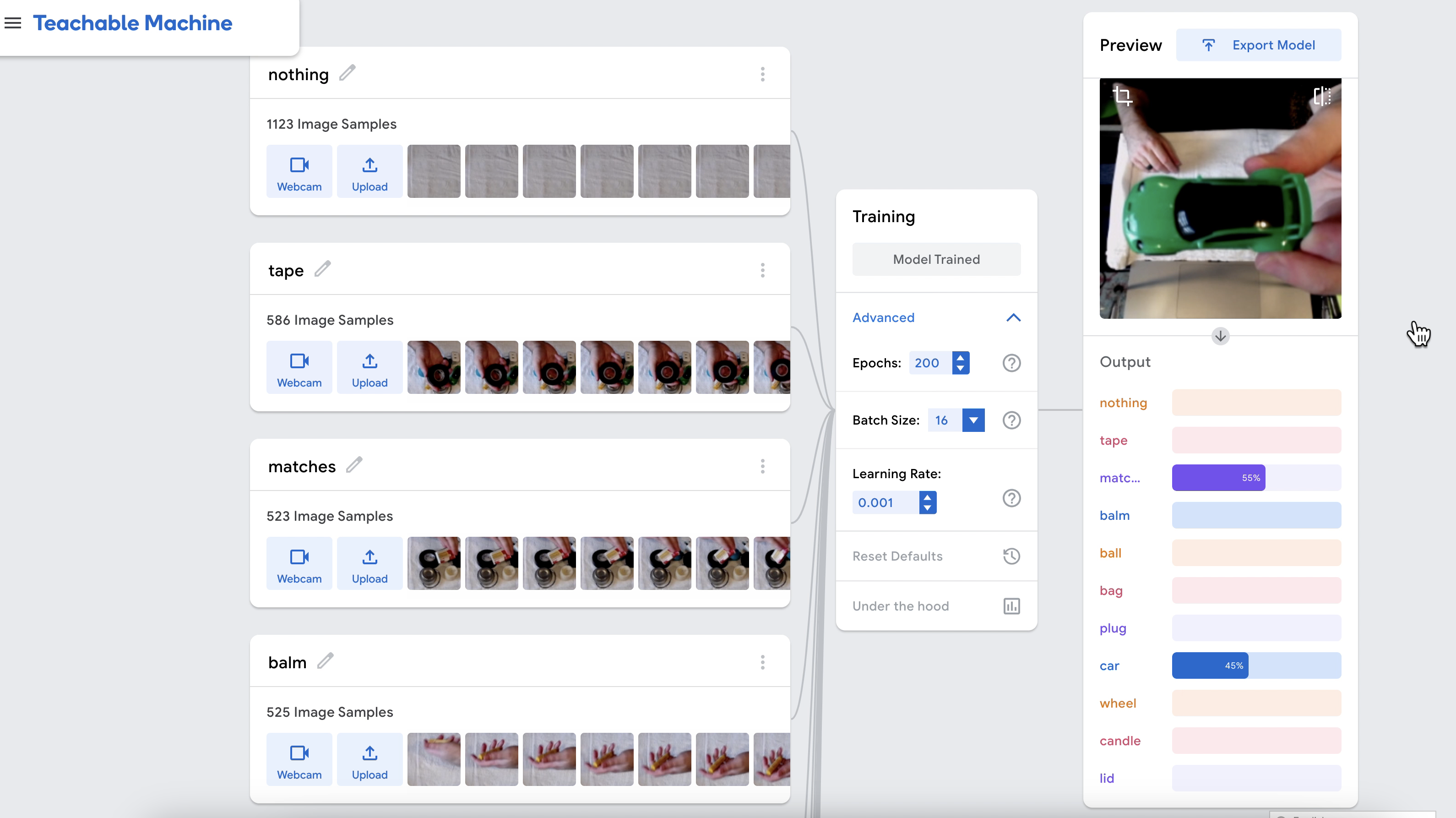 A screenshot of google's interface for training a vision model, which is learning how to identify nothing, tape, clip, ball, lemon, plant, using a webcam.